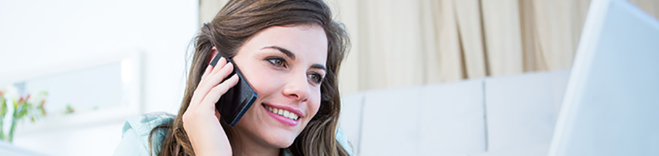 woman on phone looking at laptop